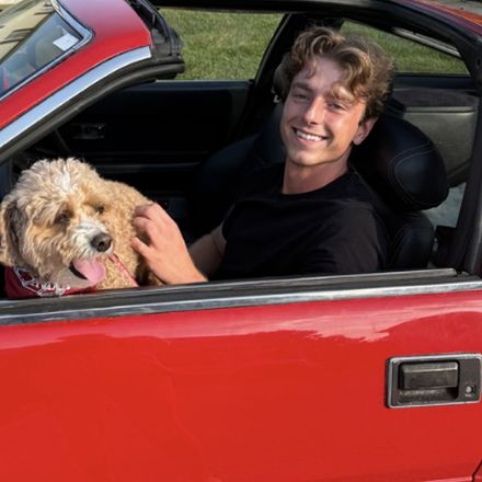 Braden Holdsworth with his dog in a red car